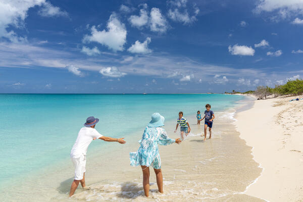 Happy family with three kids playing on a tropical beach in summer, Barbuda, Antigua & Barbuda, Caribbean, West Indies