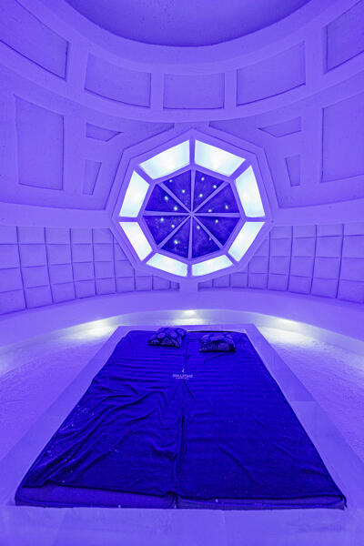 Futuristic design of an ice hotel room lit by neon lights, Lainio Snow Village, Kittila, Lapland, Finland