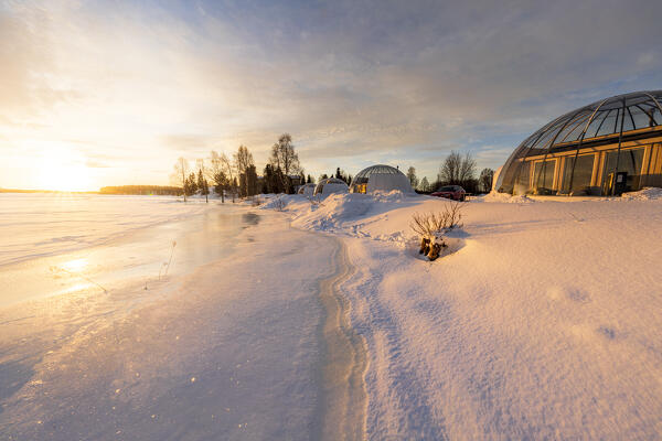 Arctic sunrise reflected on the frozen river Kalix surrounded by glass igloo in the 
Ice and Light village,
Kalix, Norrbotten county, Lapland, Sweden