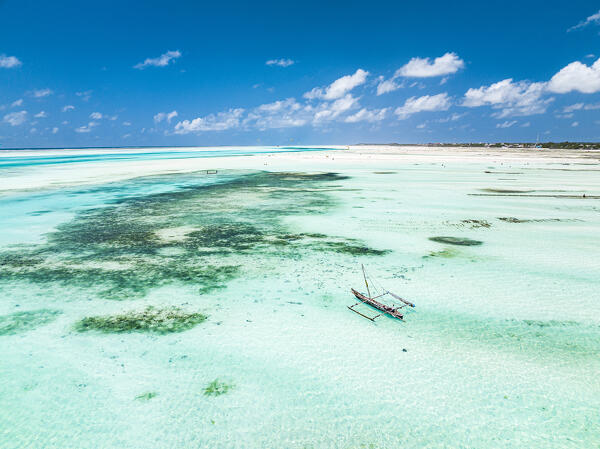 Aerial view of a dhow boat in the turquoise lagoon during  low tide, Paje, Jambiani, Zanzibar, Tanzania