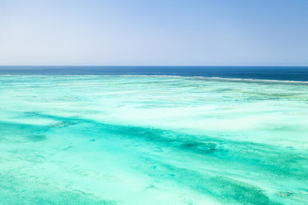 Turquoise water of lagoon meet the blue Indian Ocean, aerial view, Paje, Jambiani, Zanzibar, Tanzania