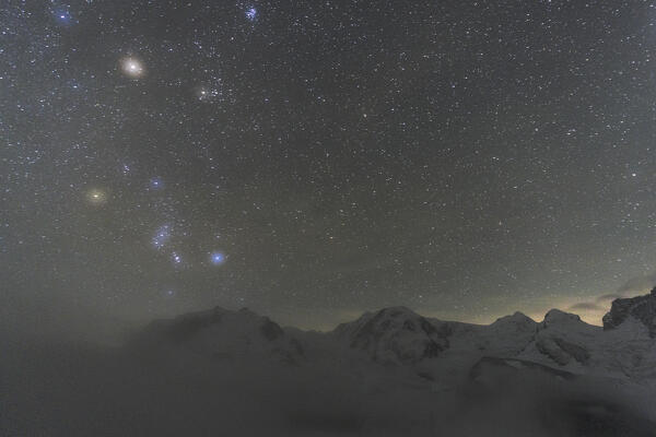 Glowing stars in the night sky over Monte Rosa covered with snow, Gornergrat, Zermatt, canton of Valais, Switzerland