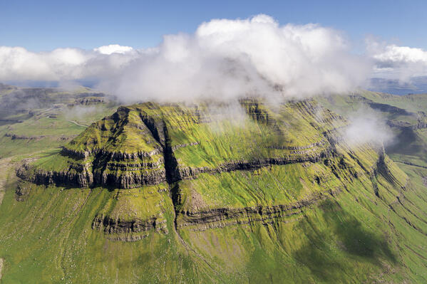 Aerial panoramic view of  Skaelingsfjall mountain peak emerging from clouds, Streymoy Island, Faroe Islands