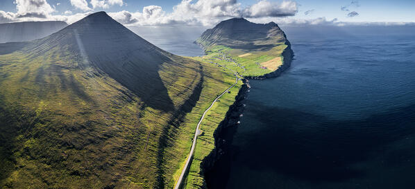 Aerial panoramic view of cliffs and empty road along the fjord nearby Vidareidi, Vidoy Island, Faroe Islands