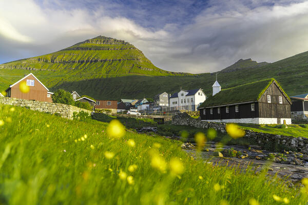 Funningur church and village surrounding by flowering meadows in summer, Eysturoy Island, Faroe Islands