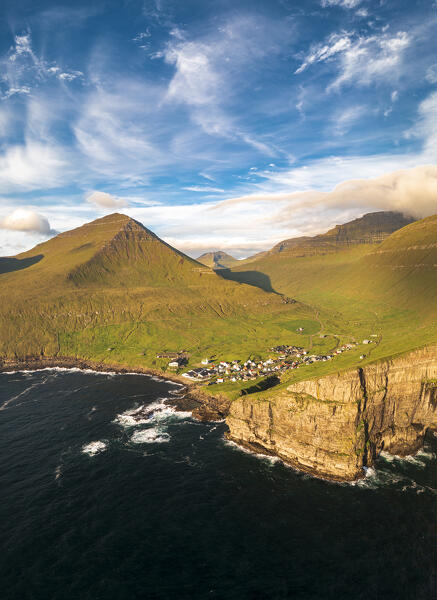 Aerial panoramic view of Gjogv on cliffs washed by waves at dawn, Eysturoy Island, Faroe Islands