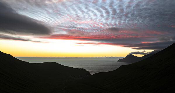 Silhouettes of Gjogv valley and Kalsoy Island under a dramtic sky at dawn Eysturoy Island, Faroe Islands