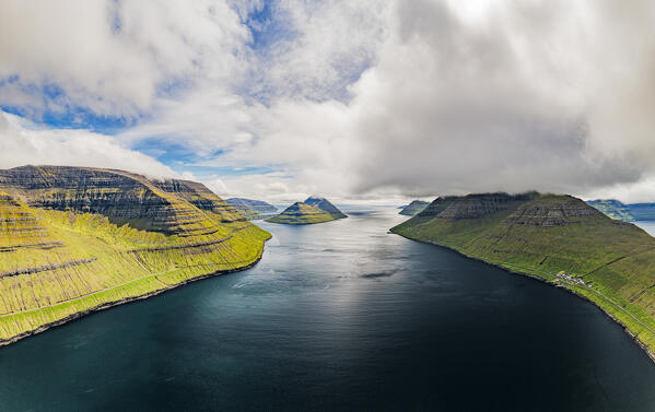 Cloudy sky over the blue Atlantic Ocean and cliffs of Kunoy and Kalsoy islands, aerial view, Faroe Island, Denmark