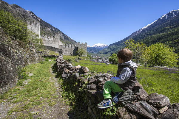 Child observes Visconti Venosta Castle. Grosio. Province of Sondrio. Valtellina. Lombardy. Italy. Europe