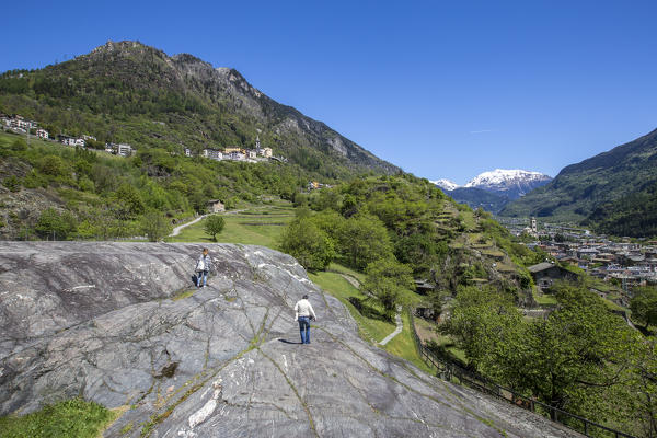 Tourists on Rupe Magna in search of petroglyphs in testimony of the first inhabitants of Valtellina. Grosio. Province of Sondrio. Valtellina. Lombardy. Italy. Europe