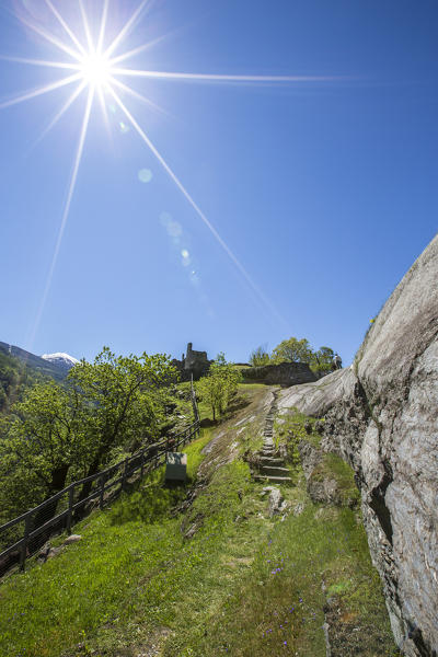 The sun shines over the castle of Visconti Venosta in Grosio. Province of Sondrio. Valtellina. Lombardy. Italy. Europe