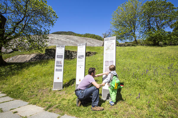 Tourists read information boards near Rupe Magna in Grosio. Province of Sondrio. Valtellina. Lombardy. Italy. Europe
