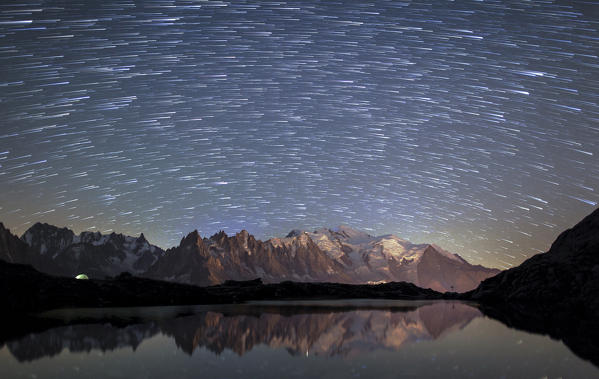 Star trail over Mont Blanc range seen from Lac de Chesery. Chamonix. Haute Savoie France