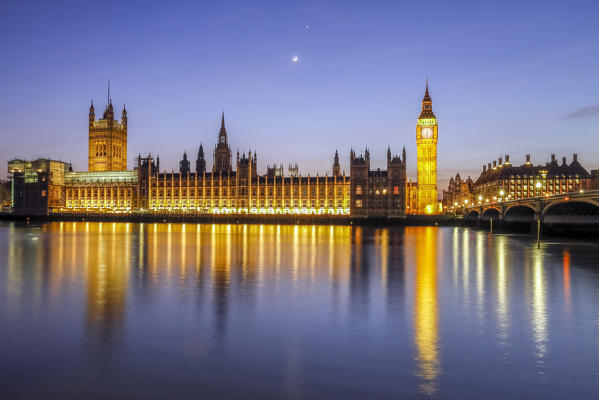 Night view of Palace of Westminster and Big Ben reflecting on Thames river. London United Kingdom Europe