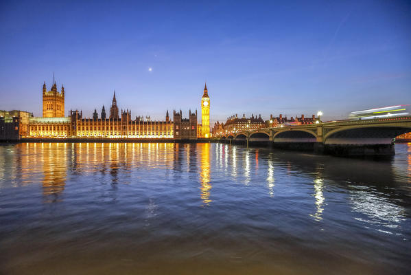 Night view of Palace of Westminster and Big Ben reflecting on Thames river. London United Kingdom Europe