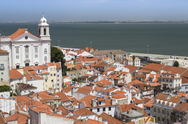 Terracotta roofs and the ancient church seen from Miradouro Alfama one of the many viewpoints of Lisbon Portugal Europe