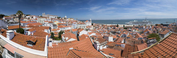 Panoramic view of terracotta roofs and the ancient castle and dome from Miradouro Alfama viewpoint of Lisbon Portugal Europe