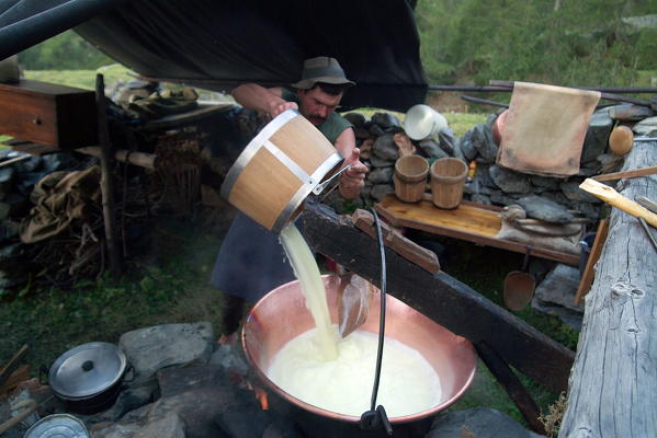 Producing Bitto cheese in Valli del Bitto, Gerola Valley, Italy. Cow's milk is immediately added to goat's (10-20 % compulsory; Orobic breed risking extinction) and then poured into the traditional coppers whose form is that of an overturned bell. Lombardy Europe
