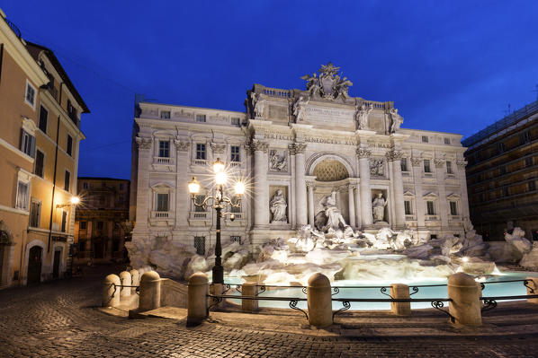 View of Trevi Fountain illuminated by street lamps and the lights of dusk Rome Lazio Italy Europe