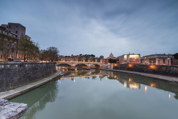 Dusk lights on Lungo Tevere with bridge Umberto I and Basilica di San Pietro in the background Rome Lazio Italy Europe