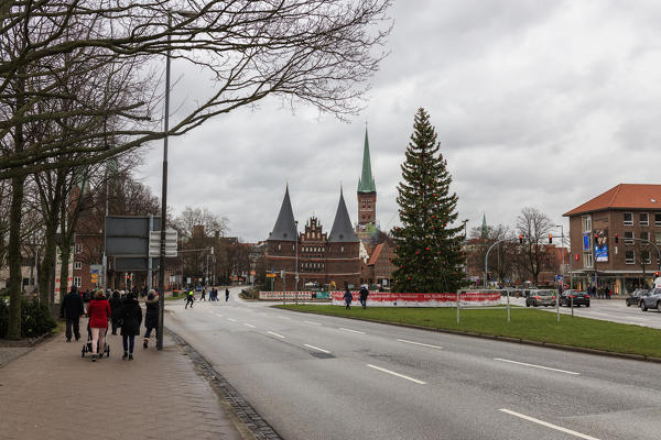 Tourists walk toward the Holstentor the city gate emblem of the city of Lübeck  Schleswig Holstein  Germany Europe