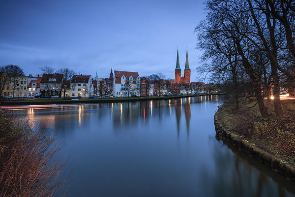 The lights of dusk on typical houses and the cathedral reflected in river Trave Lübeck Schleswig Holstein Germany Europe