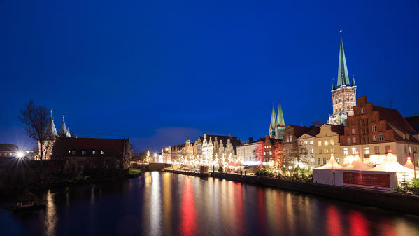 Night view of typical houses and the cathedral reflected in river Trave Lübeck Schleswig Holstein Germany Europe