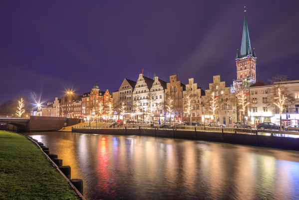 Night view of typical houses and the cathedral reflected in river Trave Lübeck Schleswig Holstein Germany Europe
