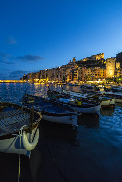 View of blue sea and boats surrounding the colorful village at dusk Portovenere province of La Spezia Liguria Italy Europe