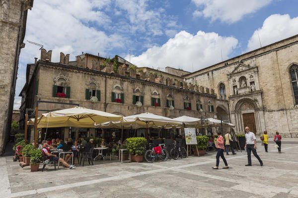 Tourists walk in the old town center surrounded by ancient buildings Ascoli Piceno Marche Italy Europe