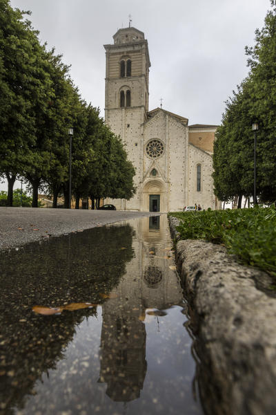 View of the facade of Fermo Cathedral reflected in a puddle Marche Italy Europe