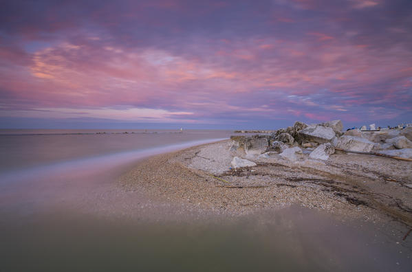 Pink sky is reflected in the clear water at sunset Porto Recanati Province of Macerata Conero Riviera Marche Italy Europe