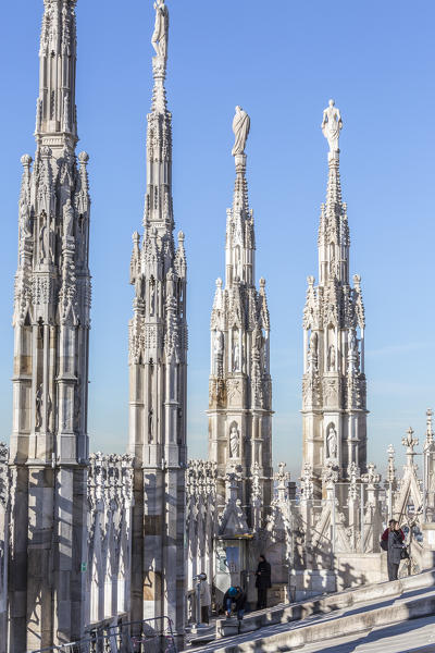 Tourists among the white marble spiers on the top of the Duomo Milan Lombardy Italy Europe