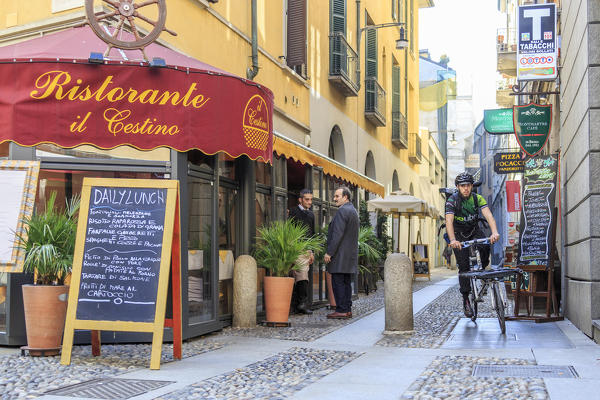 Urban bike messenger and delivery at work in the old town center of Milan Lombardy Italy Europe