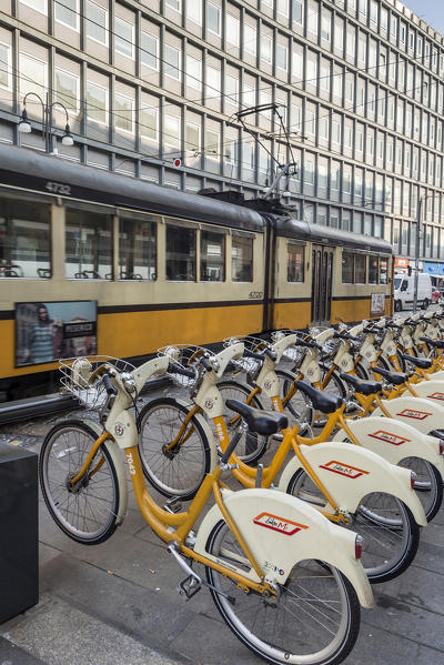 The deposit of city bikes sharing and the old yellow tram Milan Lombardy Italy Europe