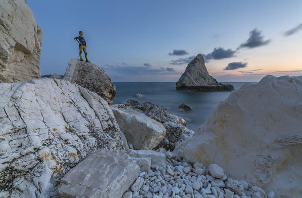 Dusk lights on cliffs framed by clear sea La Vela Beach Portonovo province of Ancona Conero Riviera Marche Italy Europe