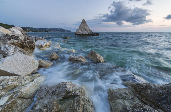 The lights of dusk on the waves crashing on cliffs La Vela Beach Portonovo province of Ancona Conero Riviera Marche Italy Europe