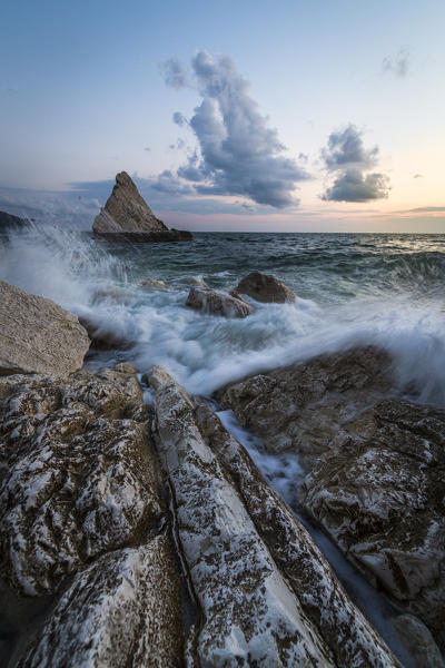 The lights of dusk on the waves crashing on cliffs La Vela Beach Portonovo province of Ancona Conero Riviera Marche Italy Europe