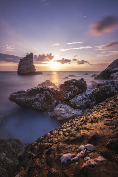 Cliffs and sea framed by the pink sky at sunrise La Vela Beach Portonovo province of Ancona Conero Riviera Marche Italy Europe