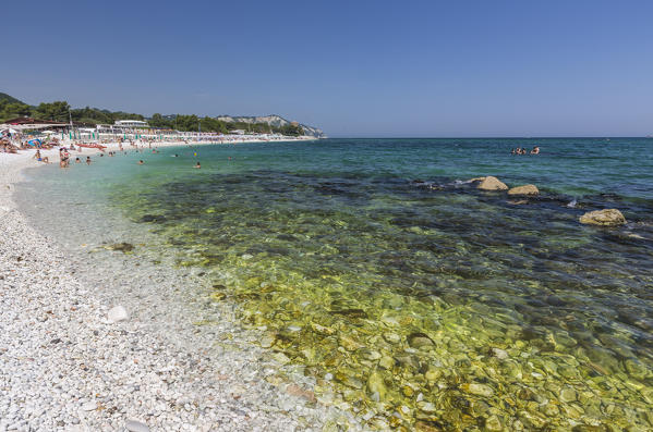 Tourists on the beach framed by the turquoise sea province of Ancona Conero Riviera Marche Italy Europe