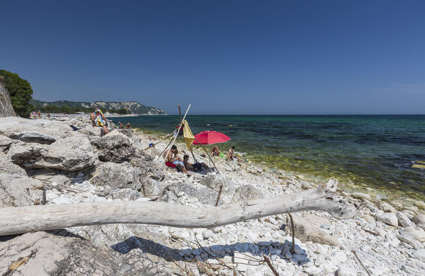 Tourists on the rocks facing the turquoise sea province of Ancona Conero Riviera Marche Italy Europe