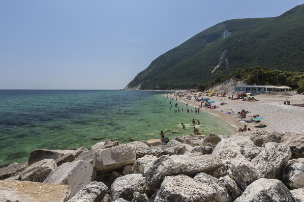 Tourists on the beach framed by the turquoise sea province of Ancona Conero Riviera Marche Italy Europe
