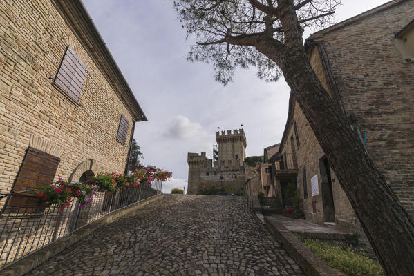 A typical alley and the old castle of the medieval village perched on the hill Offagna Province of Ancona Marche italy Europe