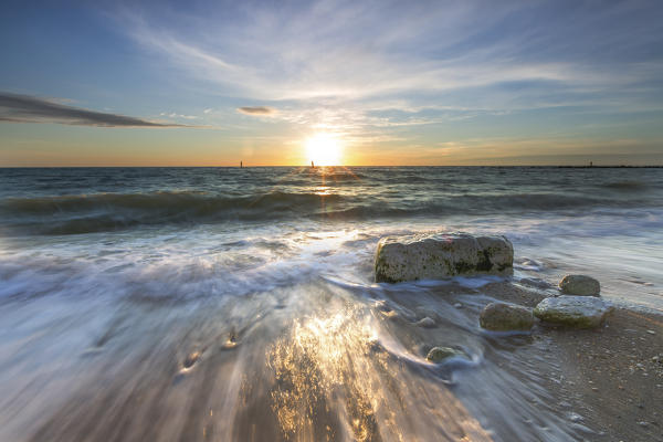 Waves crashing on the sandy beach framed by sunrise Porto Recanati Province of Macerata Conero Riviera Marche Italy Europe