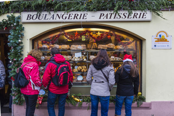 Tourists at the shop window of a pastry shop with the typical sweets Kaysersberg Haut-Rhin department Alsace France Europe