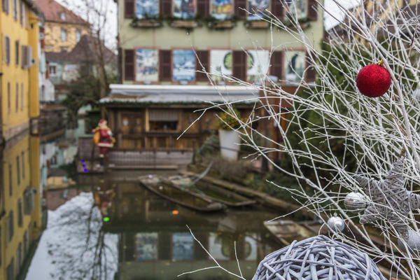 The Christmas tree frames the old town reflected in the canal Petite Venise Colmar Haut-Rhin department Alsace France Europe