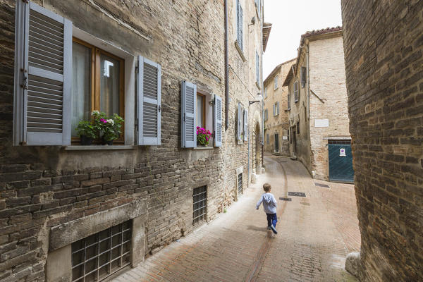 A typical alley of the ancient medieval hill town of Urbino Province of Pesaro Marche Italy Europe