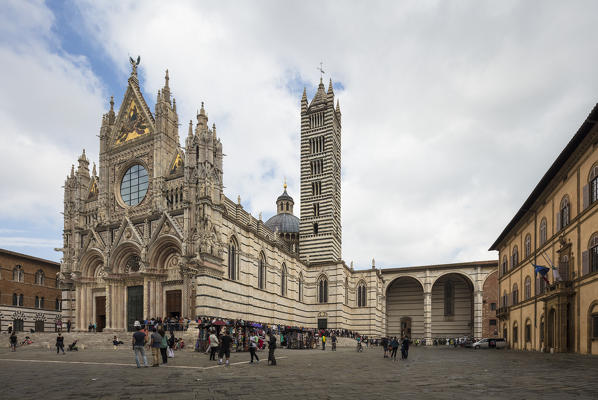 The white marble facade and the artistic decorations of the historical Siena Cathedral Tuscany Italy Europe