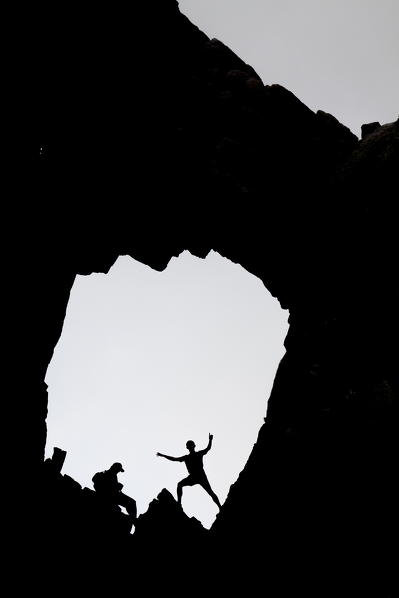 Silhouettes of people in the granitic stone arch Col de Bavella (Pass of Bavella) Solenzara Southern Corsica France Europe