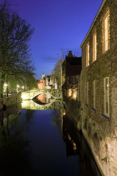 Night view of the medieval buildings of the city centre reflected in the typical canal Bruges West Flanders Belgium Europe